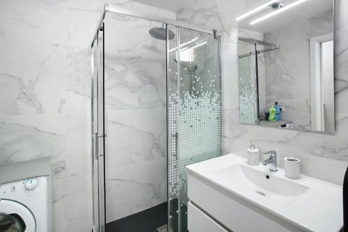 马斯帕洛马斯Bungalow Mar Azul的带淋浴和盥洗盆的白色浴室