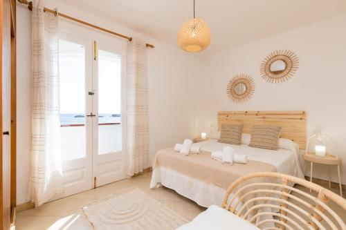 桑特柳伊斯Binilaya的一间卧室配有一张床,享有海景