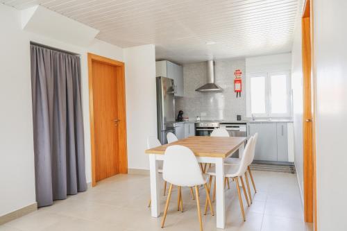 蓬德利马Casa Vilar的厨房以及带木桌和椅子的用餐室。
