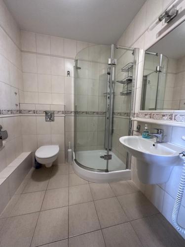 米兹多洛杰Apartament Międzyzdroje z widokiem na morze的带淋浴、卫生间和盥洗盆的浴室