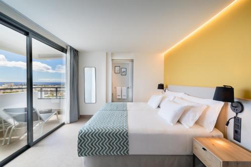 英格兰海滩Barceló Margaritas Royal Level Adults Only的酒店客房设有一张床和一个阳台。