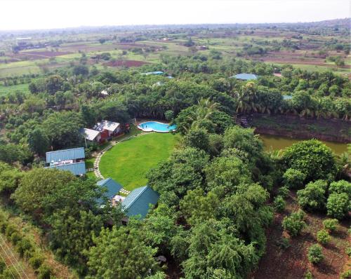 浦那Aranyagiri Countryside Resort, Near Pune的享有河流和树木的房屋的空中景致