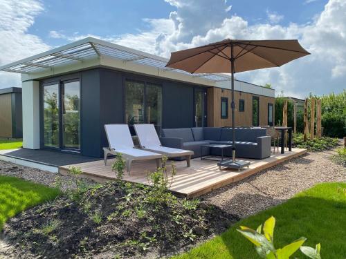 尼维莱特巴德Zonneweelde, Vakantie aan Zee的房屋设有带遮阳伞的庭院
