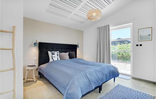 维泽桑讷Amazing Home In Hvide Sande With Outdoor Swimming Pool的一间卧室设有蓝色的床和窗户。