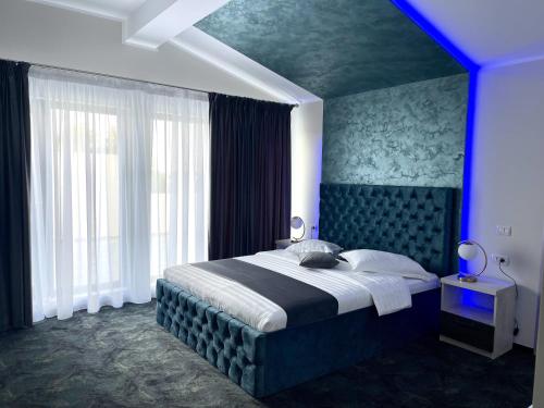 福克沙尼ZEN Hotel Focșani的一间卧室配有一张蓝色的大床