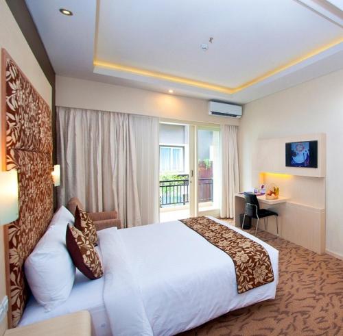 登巴萨Quest San Denpasar by ASTON的一间设有大床和窗户的酒店客房