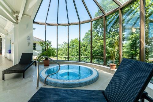 ChittlehamholtThe Mole Resort - Lodges的温室的热水浴池,设有玻璃天花板