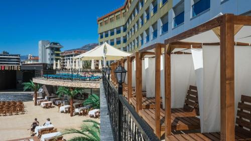 卡吉柯克Kırbıyık Resort Hotel - Alanya的阳台享有酒店的景致,配有桌椅。