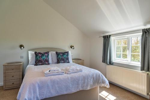 CarnbreaFinest Retreats - Trethew Cottage的一间卧室配有一张床,上面有两条毛巾