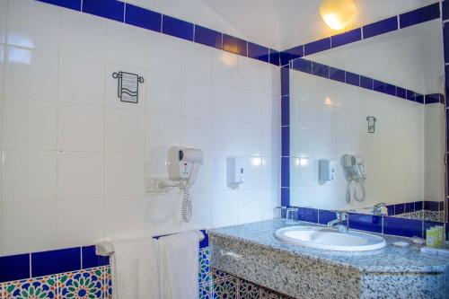 马萨阿拉姆Protels Crystal Beach Resort的一间带水槽的浴室和墙上的一部电话
