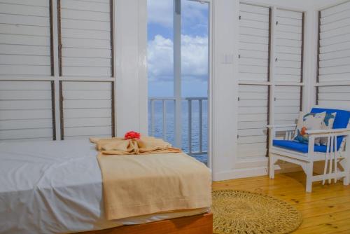 尼格瑞尔Begona Cliff Hotel的卧室配有床、椅子和窗户。