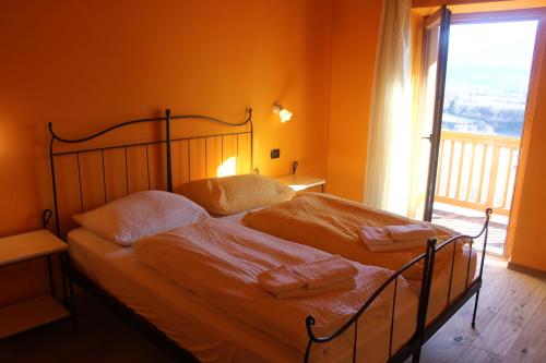罗韦雷托马索菲奥里尼乡村民宿的一间卧室配有一张带橙色墙壁和窗户的床