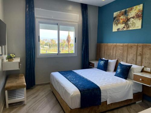 迈尔提勒HOSTAL MH BORJ的一间卧室配有一张蓝色墙壁的床和一扇窗户