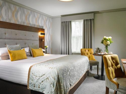 塔拉莫尔布里奇休闲Spa俱乐部酒店的酒店客房设有一张大床和一张书桌。