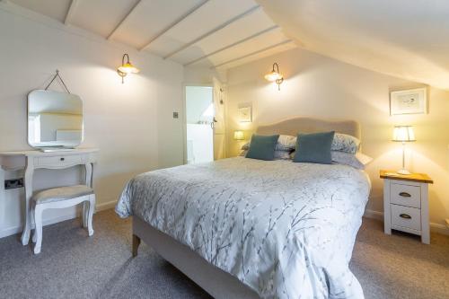 DersinghamSwift Cottage的一间卧室配有一张床、一张书桌和一台电视。