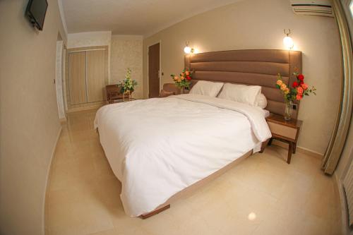 乌季达德斯利拉斯酒店的一间卧室配有一张白色大床,床上有鲜花