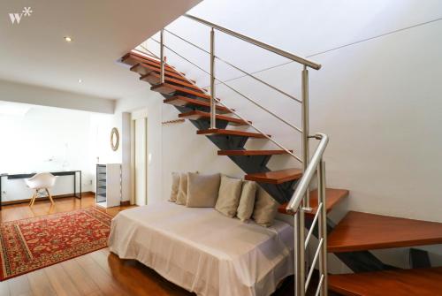利马Fantastic 2BR with private pool in Barranco的一间卧室设有一张床和一个螺旋楼梯