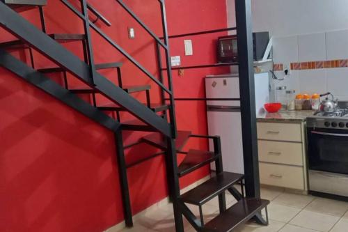 Villa BallesterDpto económico para tres en Ballester con TV的一个带红色墙壁和螺旋楼梯的厨房