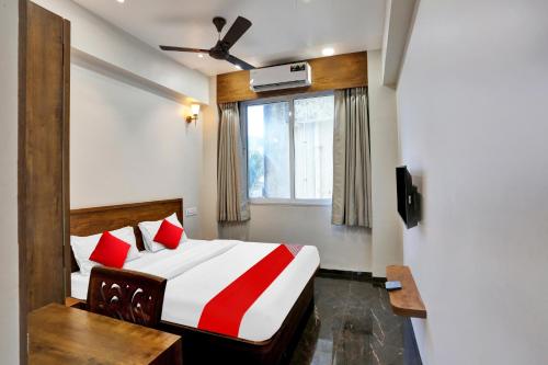 孟买Capital O Hotel Calista的一间卧室配有一张带红色枕头的床和一扇窗户