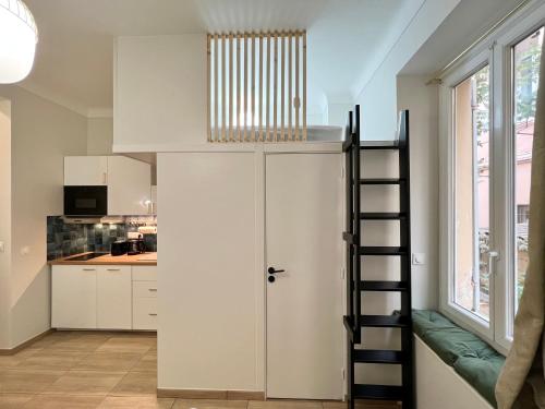 卡普戴尔Appartements neuf - Frontière de Monaco - clim - WIFI的一间设有楼梯的客房,通往厨房