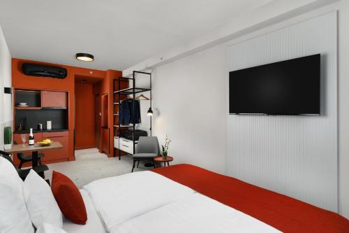 布达佩斯Florin Apart Hotel的一间卧室配有一张床,墙上配有电视