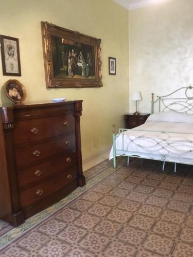 孔韦尔萨诺La dimora dei ricordi的一间卧室配有一张床和一个梳妆台