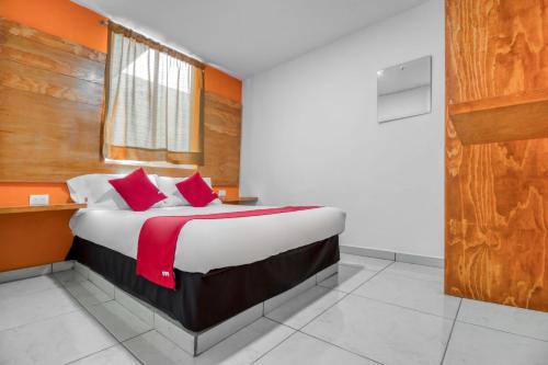 乔卢拉OYO Hotel Familiar Tollan的一间卧室配有一张带红色枕头的大床