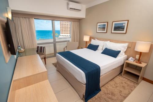 萨尔瓦多贝罗翁迪纳普拉亚酒店的一间卧室配有一张床,享有海景