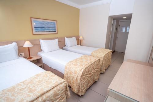 萨尔瓦多贝罗翁迪纳普拉亚酒店的酒店客房设有三张床和一张桌子