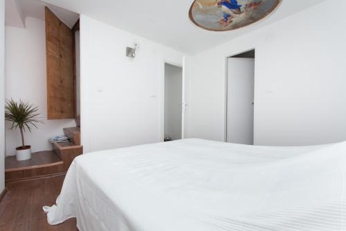 罗维尼Apartment Zdenac的卧室配有白色的床和镜子