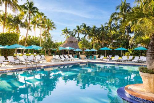 迈阿密海滩棕榈树Spa酒店的度假酒店的游泳池配有椅子和遮阳伞
