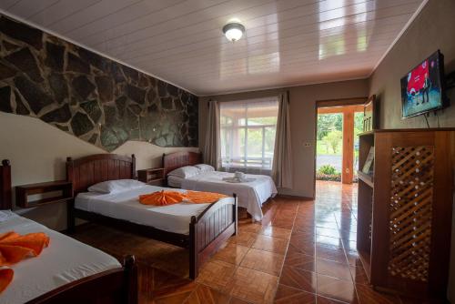 福尔图纳Hotel & Hot Springs Sueño Dorado的一间卧室设有两张床和石墙