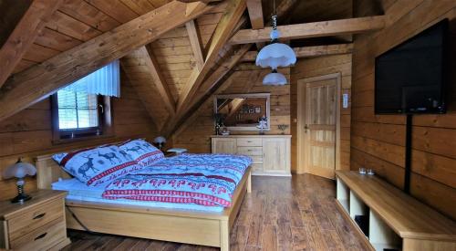上洛姆纳Roubenka Lomná的小木屋内的卧室配有1张床和1台平面电视