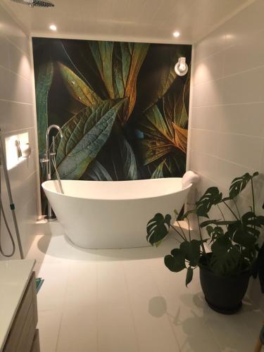 ValbergValberg Gjestegård的浴室配有带大型植物壁画的浴缸