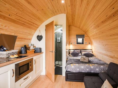 拉努辛Celyn Bach - Uk37083的木制客房内的一间卧室,配有一张床