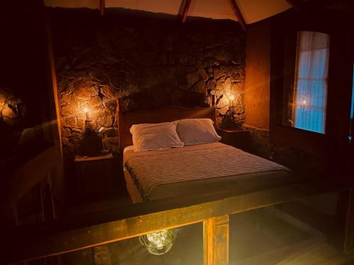 AlcoguazAlcohuaz Indomito的一间卧室设有一张床和石墙