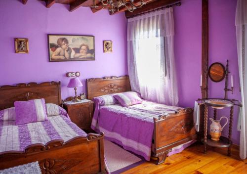 波拉-德拉维亚纳Casa Rural La Aldea的紫色卧室设有两张床和一扇窗户
