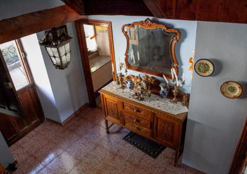 波拉-德拉维亚纳Casa Rural La Aldea的墙上的镜子,旧木梳妆台