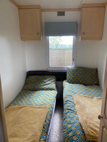 麦克尔斯菲尔德Monks Heath fold mobile home的小型客房 - 带2张床和窗户
