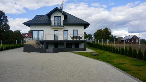 Dąbrowa Grodzieńska-WieśAgroturystyka Ostrowie的黑色屋顶的大型白色房屋