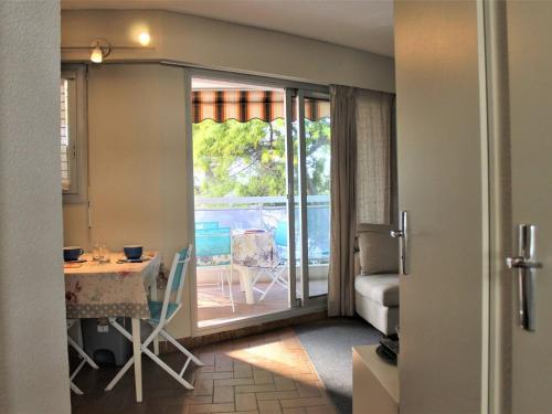 卢贝新城Appartement Villeneuve-Loubet, 2 pièces, 3 personnes - FR-1-252A-102的一间设有一扇门的客房,可通往带桌子的阳台