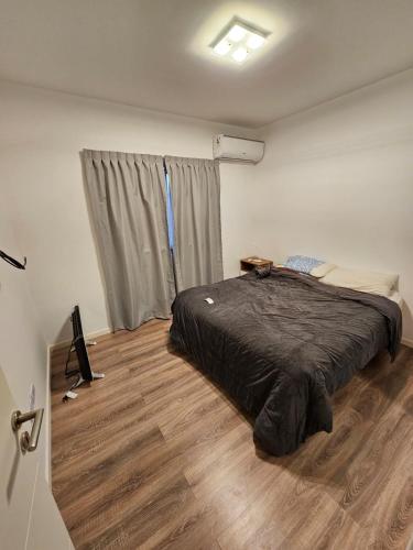 贝伦埃斯科巴Departamento amoblado con balcón y cochera en la entrada de escobar的一间卧室配有一张床,铺有木地板