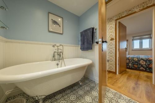 Bumblebee Cottage的带浴缸的浴室和卧室