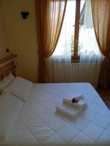 OrsenigoRESIDENZA BERETTA Como Lake -A-的卧室配有白色的床、毛巾和窗户