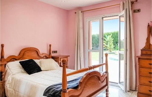 康达Nice Home In Antromero With Kitchen的卧室设有粉红色的墙壁、一张床和窗户