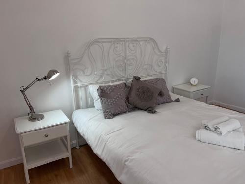 里加Swedish Gate Apartment in Old Town的一间卧室配有一张带灯的白色床和2个床头柜