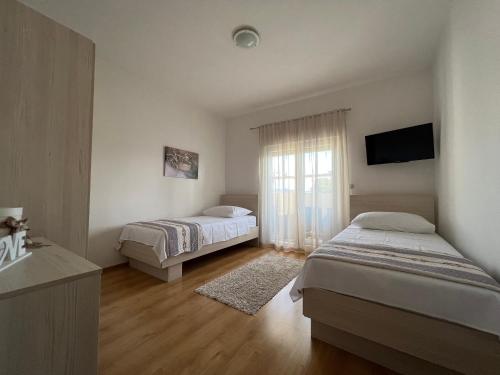 苏科尚Apartman Burčul的一间卧室配有两张床和电视。