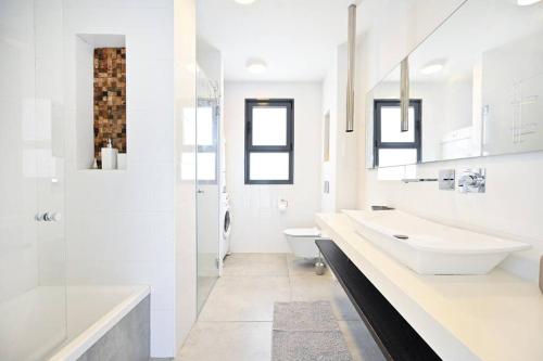 内坦亚Luxury Penthouse in Netanya的白色的浴室设有2个盥洗盆和1个卫生间。