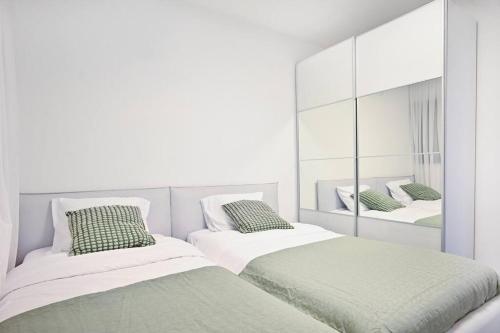 内坦亚Luxury Penthouse in Netanya的白色客房的两张床,配有镜子