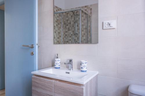 莱里奇Appartamento con parcheggio e Aria Condizionata的白色的浴室设有水槽和镜子